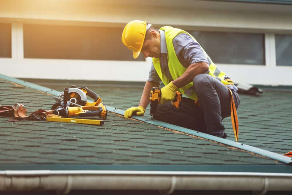 Roofer working in protective work wear gloves,