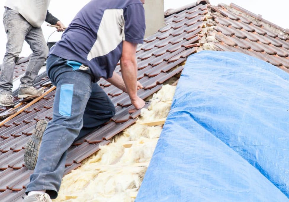 a roofer laying tile on the roof